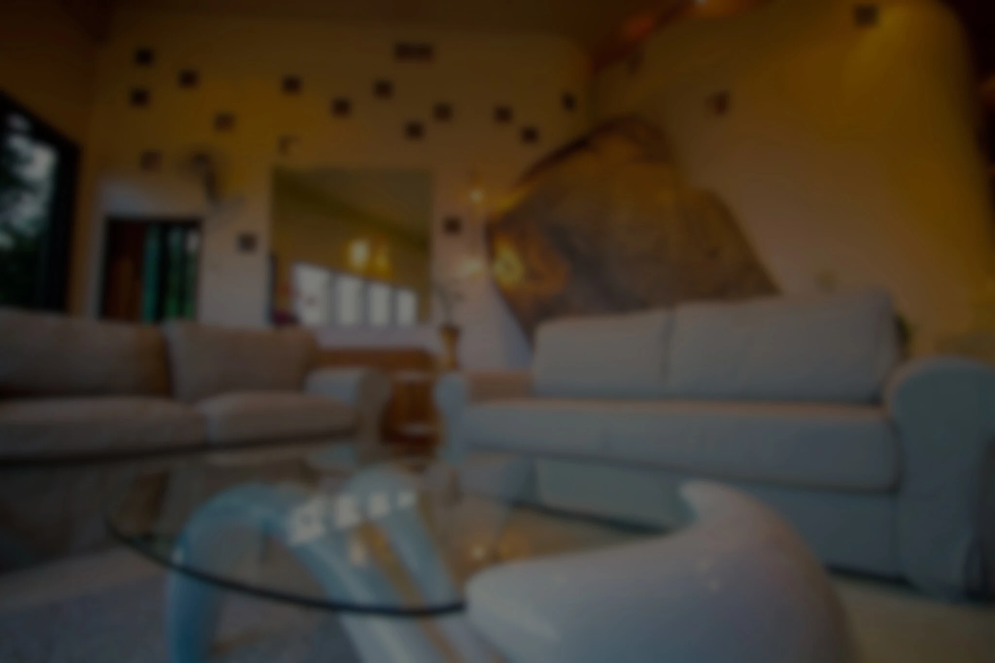 Interior of a luxury Koh Tao villa living room with large windows showcasing the tropical greenery and ocean views. Features stylish furniture and nature-inspired architecture.