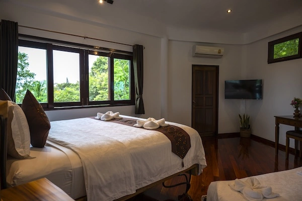 Second luxury bedroom featuring tropical decor and premium bedding at The Orchid Villa